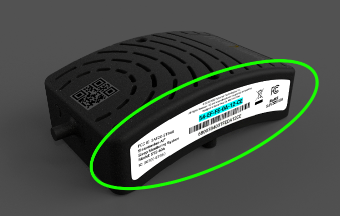 A top-down view of a black Sleeptracker-AI processor, oriented with its USB cable pointing up, with the circular vents facing towards the viewer. To the left is a small black circular port, labeled 
